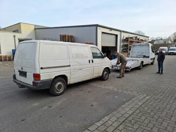 Ausgedienter gewerblicher Kastenwagen wird mit einem Autotransporter zur Fahrzeugverwertung abgeholt