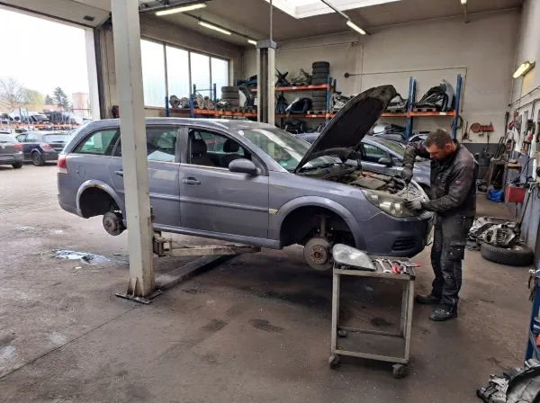 Autoverschrottung Hattingen: Mitarbeiter demontiert ein Schrottauto in einem Fahrzeugverwertungsbetrieb