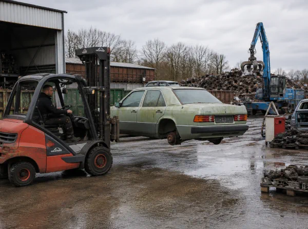 Autoverschrottung Herten: Schrottauto wird auf einem Fahrzeugverwertungshof mit einem Gabelstapler transportiert