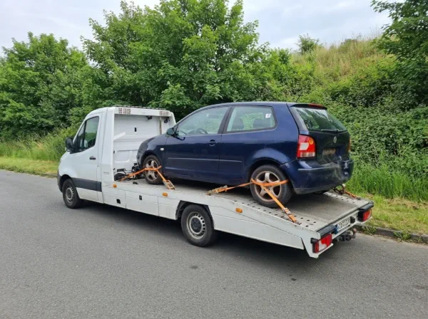 Autoverwertung Herdecke: Beschädigtes Schrottauto ist vollständig auf einem Autotransporter verladen und gesichert