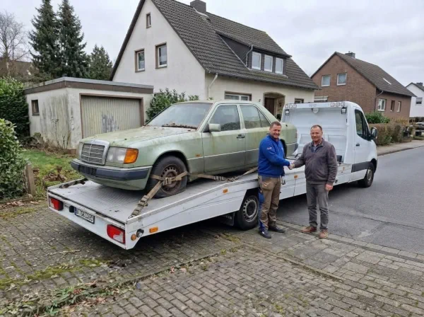 Autoverwertung Herten: Schrottauto steht verladen auf dem Autotransporter und wird an den Mitarbeiter übergeben