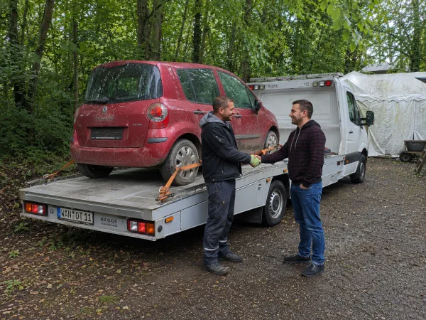 Autoverwertung Sprockhövel: Schrottauto ist auf dem Autotransporter verladen und wird an den Mitarbeiter übergeben