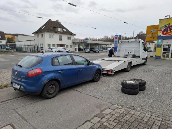 Altfahrzeug mit zusätzlichem Radsatz aus vier Reifen und Felgen wird für die gemeinsame Abholung vorbereitet